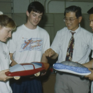 Professor Andrew Frank and three students look at small model cars in 1992 photo.